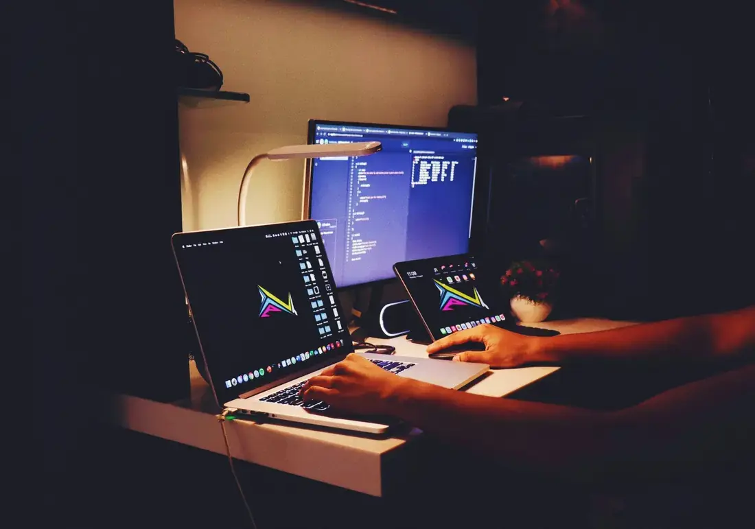 image of worker working on multiple monitor